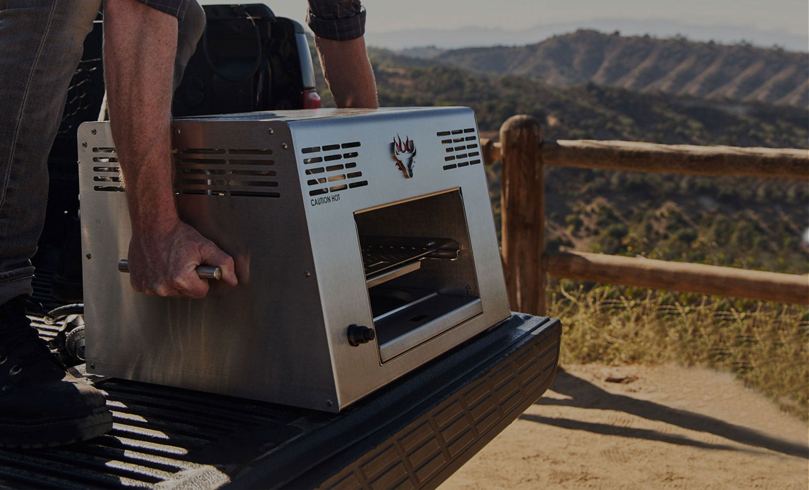 Man carrying Schwank Grill by side handles