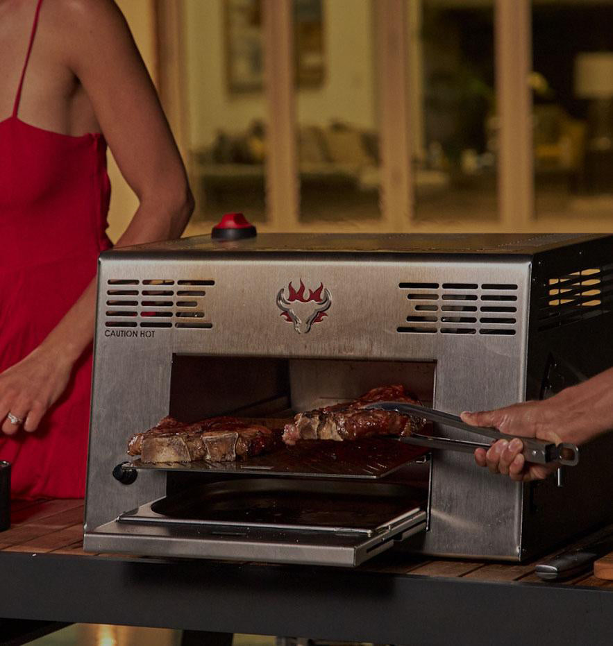 Man and woman grilling steak on Schwank Grill